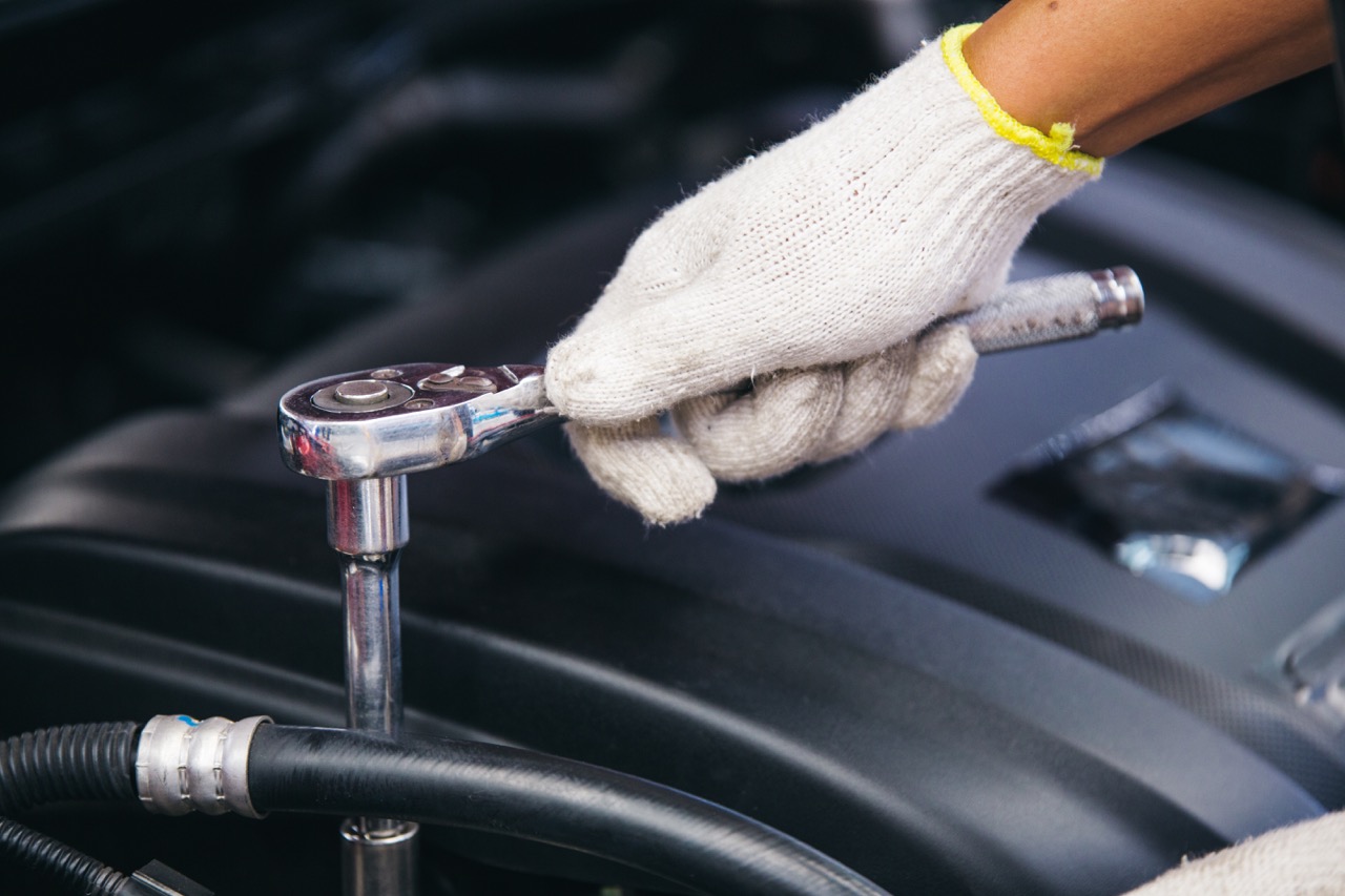 Mechanic using a ratchet on an engine